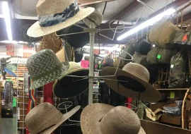 A tall display rack full of straw hats